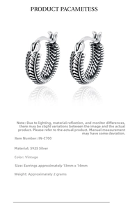 Detail of vintage S925 sterling silver hoop earrings with intricate feather engraving