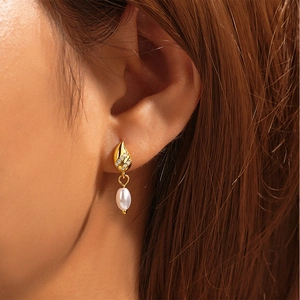 Detailed close-up of a s925 silver star pearl earring worn on a female model