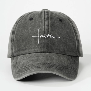 Close-up of white FAITH script embroidery on dark gray washed cotton baseball cap