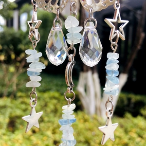 Detail of crystal suncatcher with silver moon, star motifs and light blue natural stones