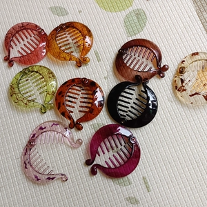 Flat lay of colorful circular banana hair clips in amber, tortoiseshell and resin finishes