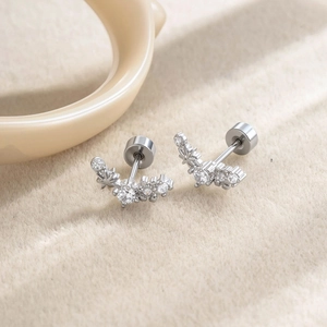 Exquisite silver micro-set zircon star earrings displayed on a soft beige fabric