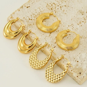 Detailed view of three pairs of gold U-shaped earrings with striped and embossed patterns