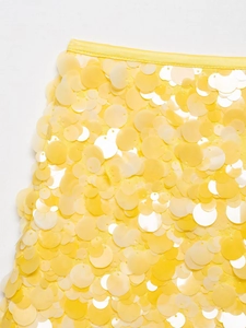 Vue détaillée des paillettes rondes jaunes et de la couture de la taille d'une jupe