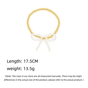 Detail shot of a beaded gold bracelet with a pearl bowknot, showing 17.5cm length specifications
