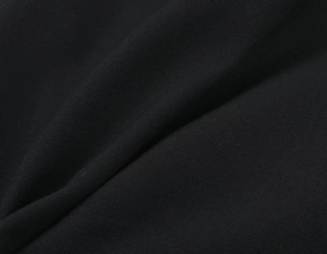 Dettaglio ravvicinato del tessuto nero dell'abito con spalline e trama diagonale definita