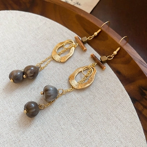 Close-up of vintage geometric earrings with wood cubes and natural seed tassels