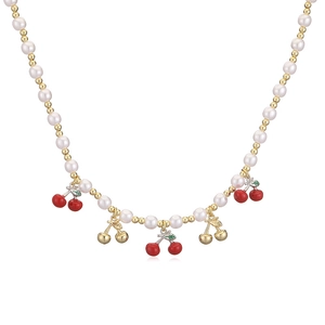 Close-up of pearl bead necklace with red cherry pendants and gold metallic accents