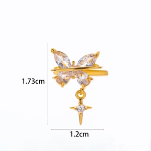 Macro view of gold butterfly ear cuff with marquise zircons and star pendant detail