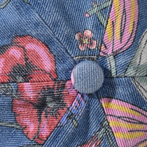 Close-up of denim baseball cap showing indigo twill texture and vibrant floral patterns