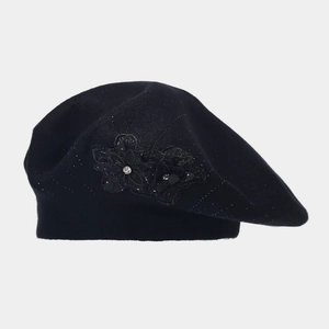 Detailed view of the black knitted beret with intricate lace flower and sparkling rhinestones