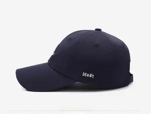 Detail view of the navy blue baseball cap featuring white 3D Meet embroidery on the side