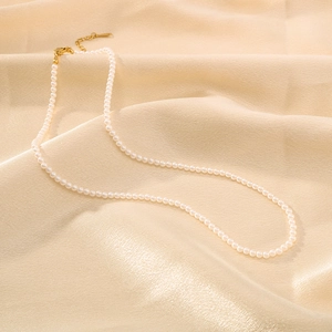 18k gold plated pearl pendant necklace for women on champagne silk fabric background