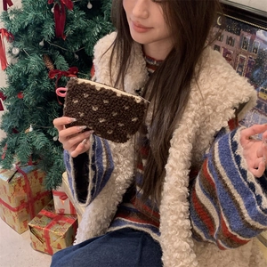 Close-up of brown plush coin purse with white dots shown in a festive Christmas setting