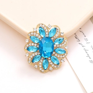 Macro shot of blue crystal flower accessory with gold base and sparkling rhinestones