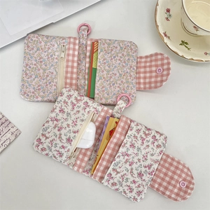 Floral fabric multi-functional wallet with card slots and zipper pocket on desktop