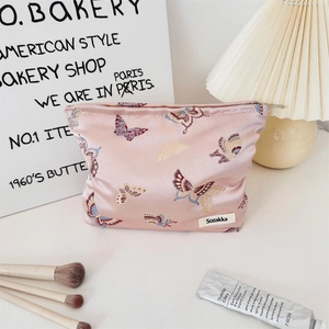 Detailed close-up of pink satin jacquard butterfly bag with smooth zipper and brand label