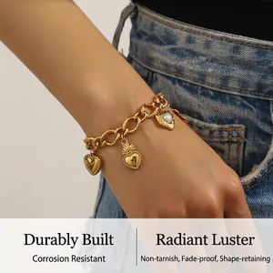 Detailed shot of a gold-plated Cuban chain bracelet with vintage heart charms and opal stones