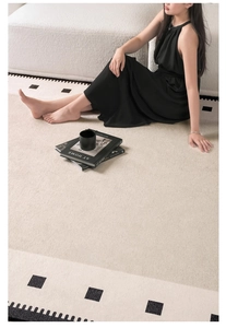Detail of beige chenille rug featuring black geometric patterns and elegant fringed edges