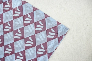 Detail of burgundy and light blue mesh fabric with geometric diamond printing