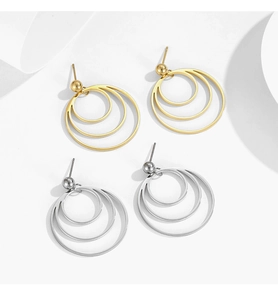 Macro shot of geometric multi-layer circle stud earrings in gold and silver stainless steel