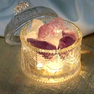 Detail of crystal glass storage jar with purple stones and warm LED light base