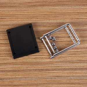Detailed view of Newton's cradle black base and steel frame on wooden table