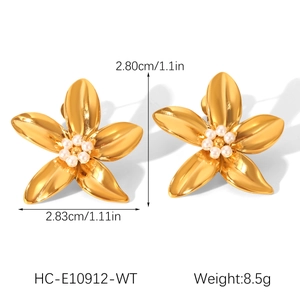 Detailed close-up of golden five-petal flower earrings with elegant white pearl center