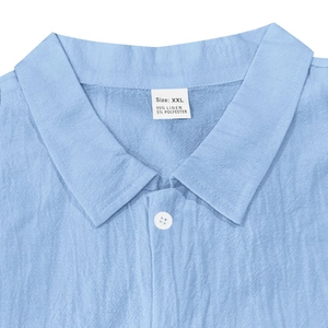 Détail du col d'une chemise en lin bleu clair avec texture et étiquette XXL