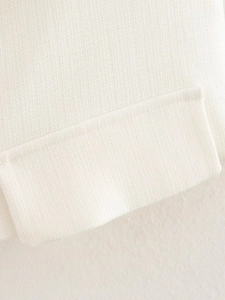 Detailed close-up of white textured cotton-blend fabric with premium stitching craftsmanship