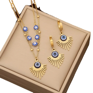 Golden stainless steel jewelry set featuring blue evil eye sunburst necklace and earrings