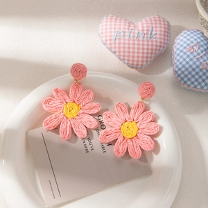 Handmade pink raffia daisy earrings with yellow center for a bohemian summer vacation look