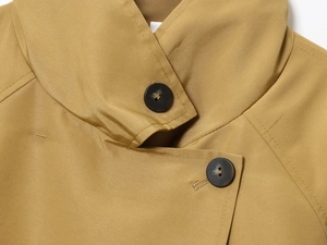 Detailed close-up of khaki trench coat collar featuring twill fabric and dark brown buttons