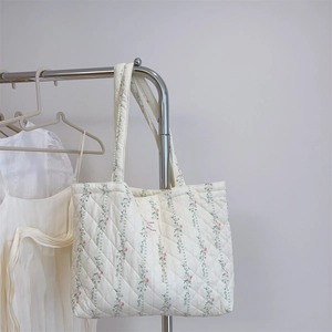 Détail du sac cabas en coton matelassé avec motifs floraux roses et étiquette tissée