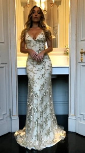 Close-up detail of gold and white sequins on a sexy V-neck evening gown dress