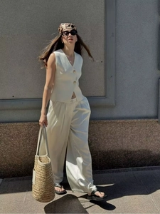Detailed view of white knit vest top paired with elegant satin wide-leg pants