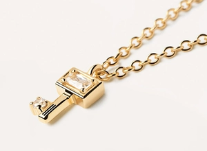 Macro shot of 925 silver key pendant with zircon stones and fine gold plating
