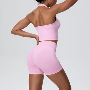 Detailed back view of pink seamless ribbed yoga set showing halter bra and high-waist shorts