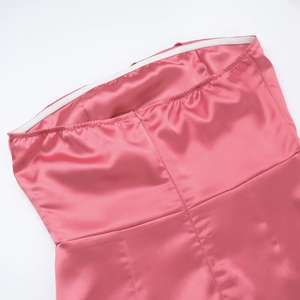 Detail of pink satin tube dress featuring elastic band and invisible zipper closure