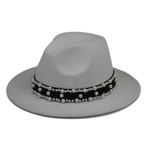 Detailed view of white pearls and black ribbon trim on a light gray wool fedora hat