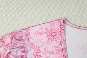 Gros plan détaillé du col en V et de l'imprimé floral sur la robe à manches bouffantes