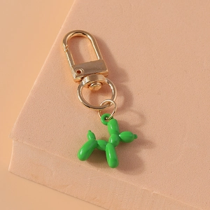 Detail of creative balloon dog keychain with vibrant green finish and gold metal hook