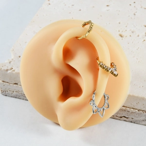 Detailed view of gold and silver nose rings with marquise zircon on a silicone model