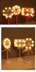Detail of wooden Christmas LED stop sign with reindeer and Santa Claus warm lighting