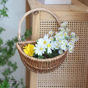 Détail d'un panier en osier semi-circulaire mural avec des marguerites blanches et jaunes