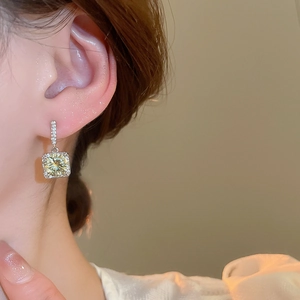 Close-up of model wearing square champagne zircon earrings with silver plating