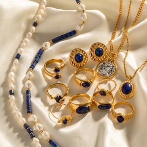 Retro gold jewelry set with lapis lazuli and Roman coin pendant on beige silk
