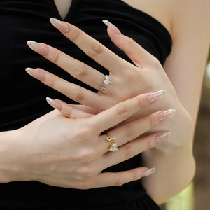 Model wearing stacked silver and gold heart-shaped rings with sparkling zircon inlay