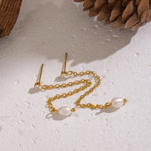 Detail of gold-plated chain tassel earrings with freshwater pearls and zircon stones