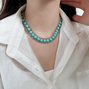 Gros plan d'un collier bohème double rang en turquoise avec strass sur base argentée
